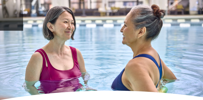 Two women talking in a swimming pool